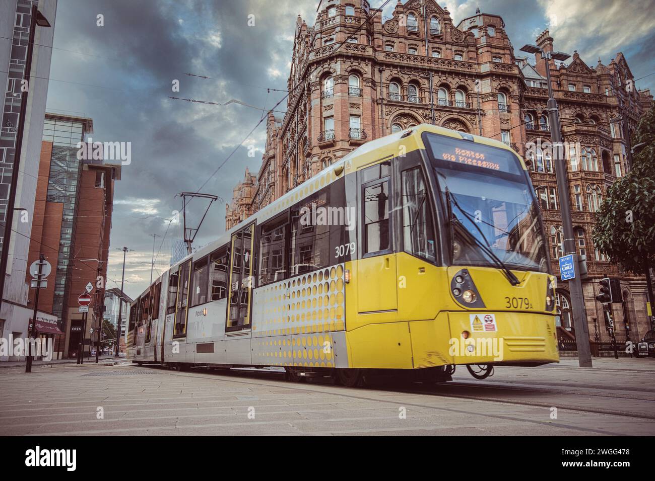 A vibrant yellow tram in the streets of Manchester, UK. Stock Photo