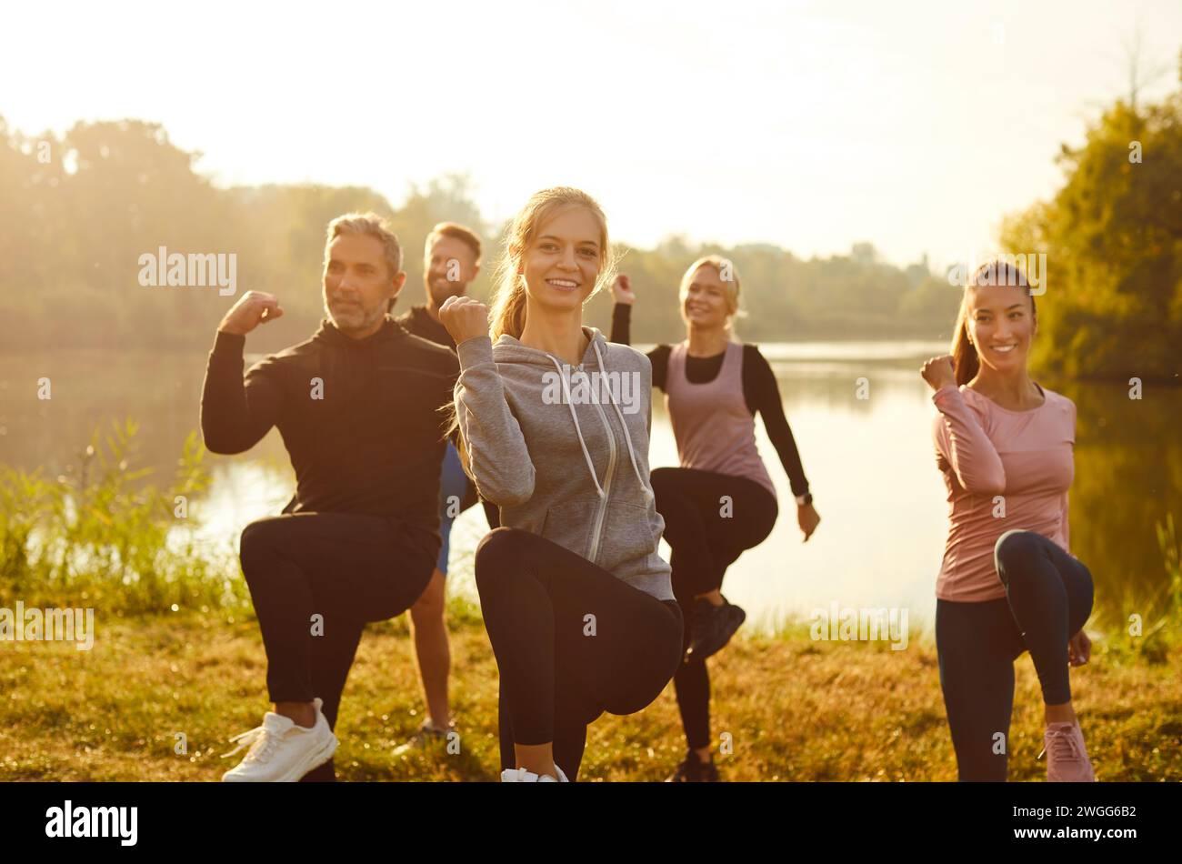 Group of fit and active people doing sport exercising in nature. Outdoors fitness concept. Stock Photo