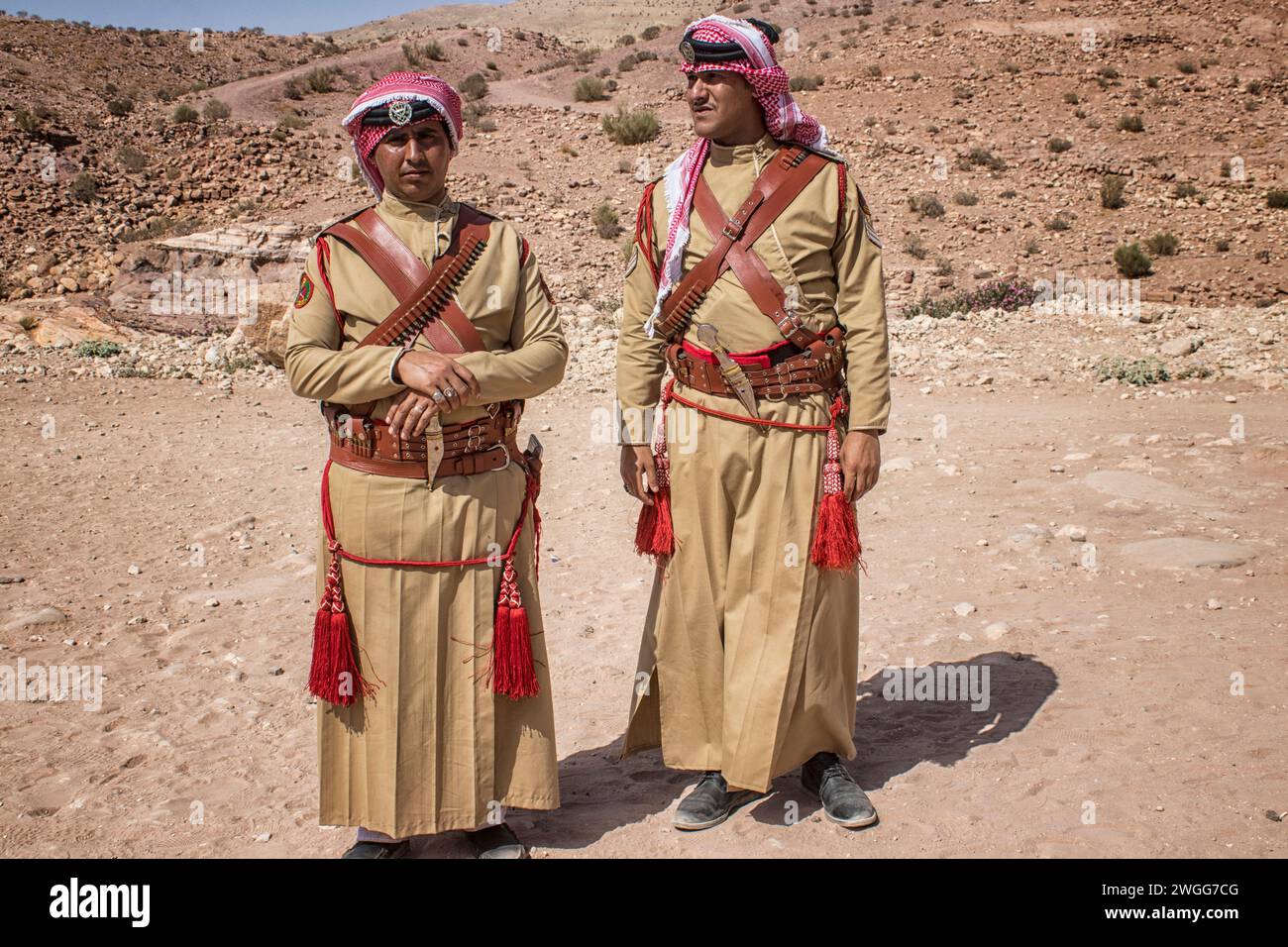 Two Jordanian Police officers that patrol the UNESCO site. Petra, is a historic and archaeological city in southern Jordan. Famous for its rock-cut architecture and water conduit system, Petra is also called the 'Rose City' because of the colour of the sandstone from which it is carved. It is adjacent to the mountain of Jabal Al-Madbah, in a basin surrounded by mountains forming the eastern flank of the Arabah valley running from the Dead Sea to the Gulf of Aqaba. Access to the city is through a famously picturesque gorge called the Siq, which leads directly to the Khazneh. Jordon. Stock Photo