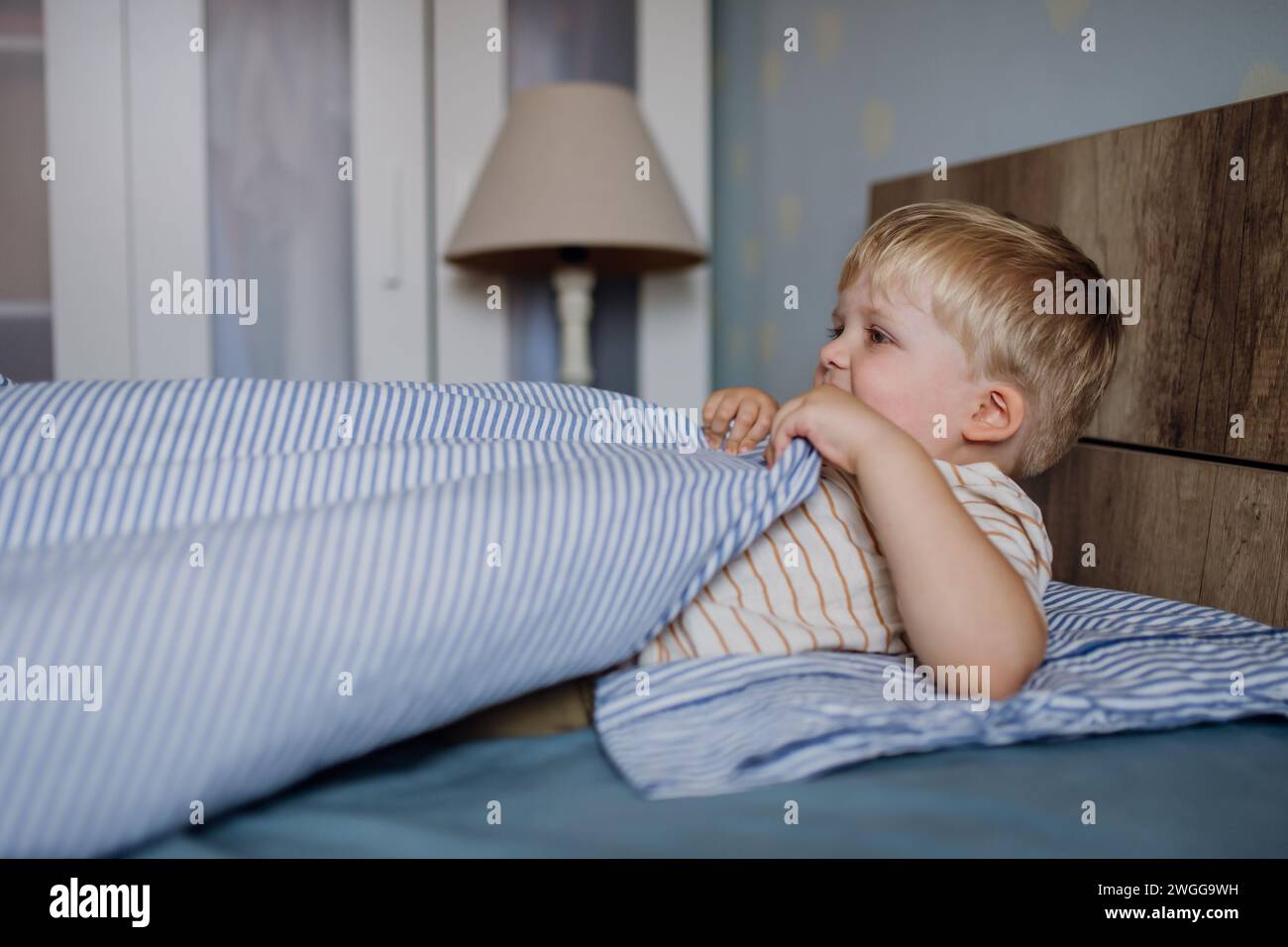 Portrait of little baby boy waking up in the morning. Sleep training for toddlers. Stock Photo