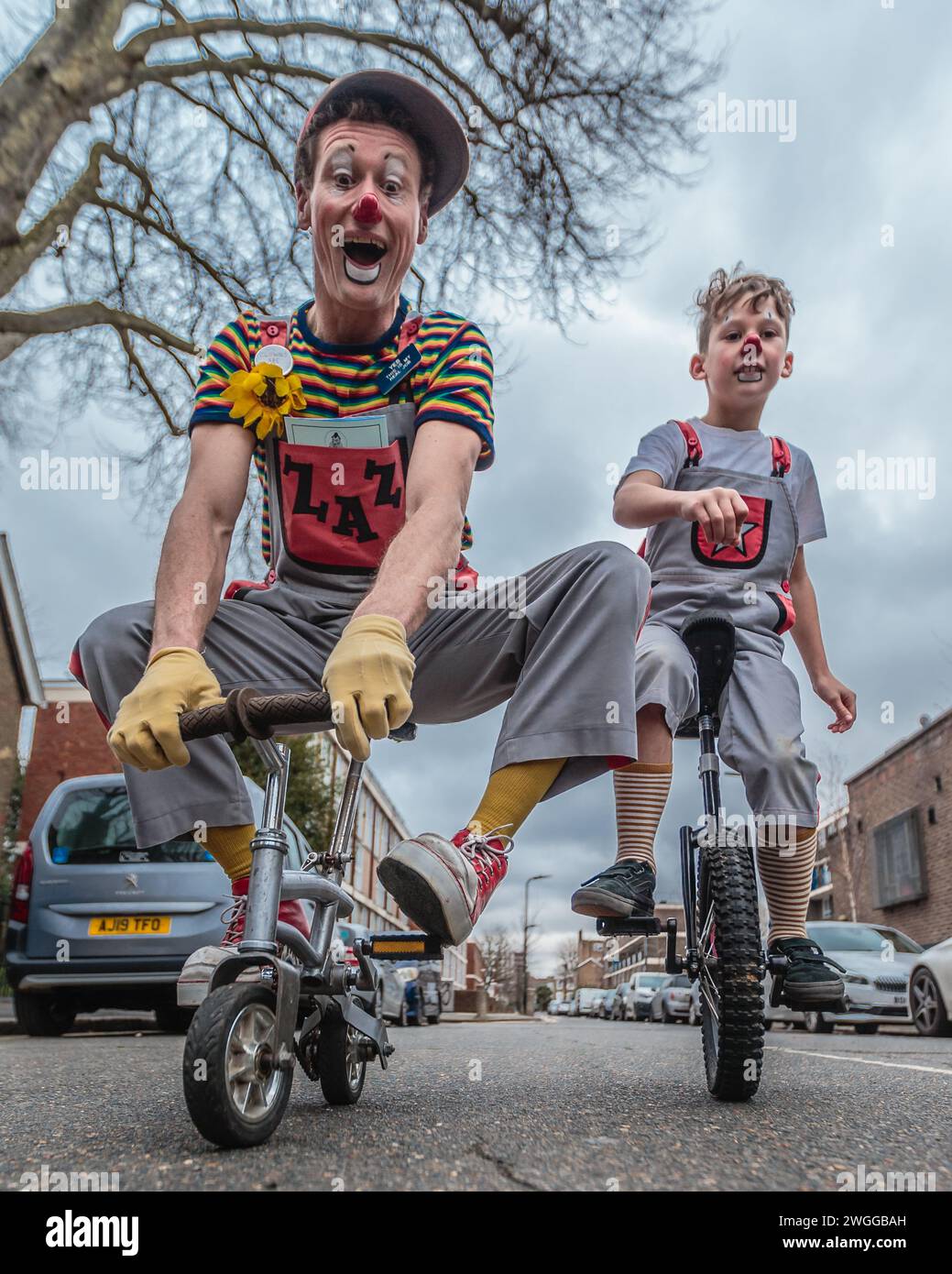 Clowns on a unicycle and a mini-bicycle at the  Joseph Grimaldi event. Stock Photo