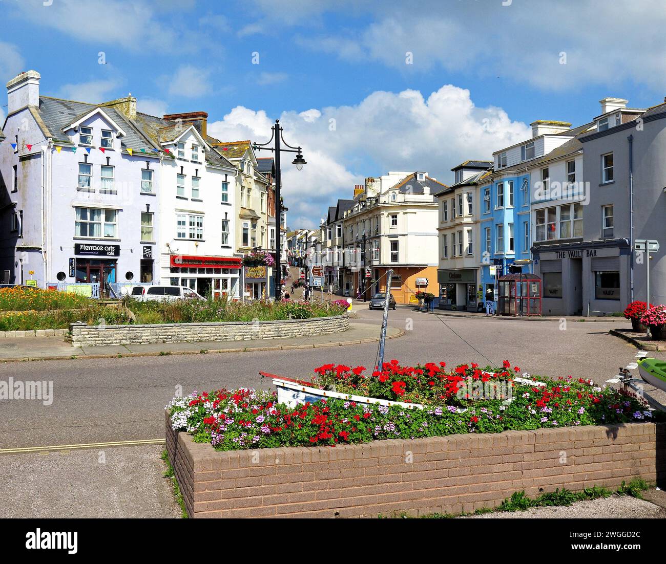 View of Fore Street shops in the town centre with pretty flowerbeds in ...