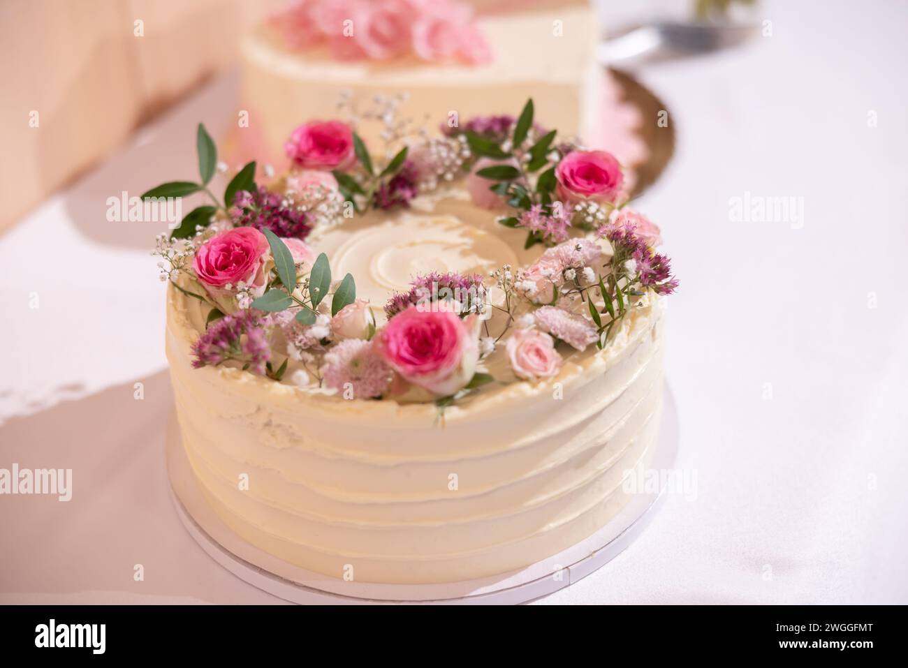 Wedding cake with red marzipan roses on the wedding table. Stock Photo