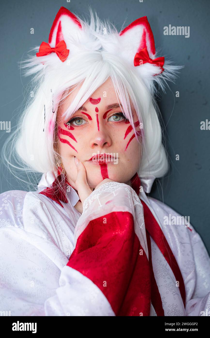 A cosplayer dressed in a Japanese white and red cat priestess costume Stock Photo