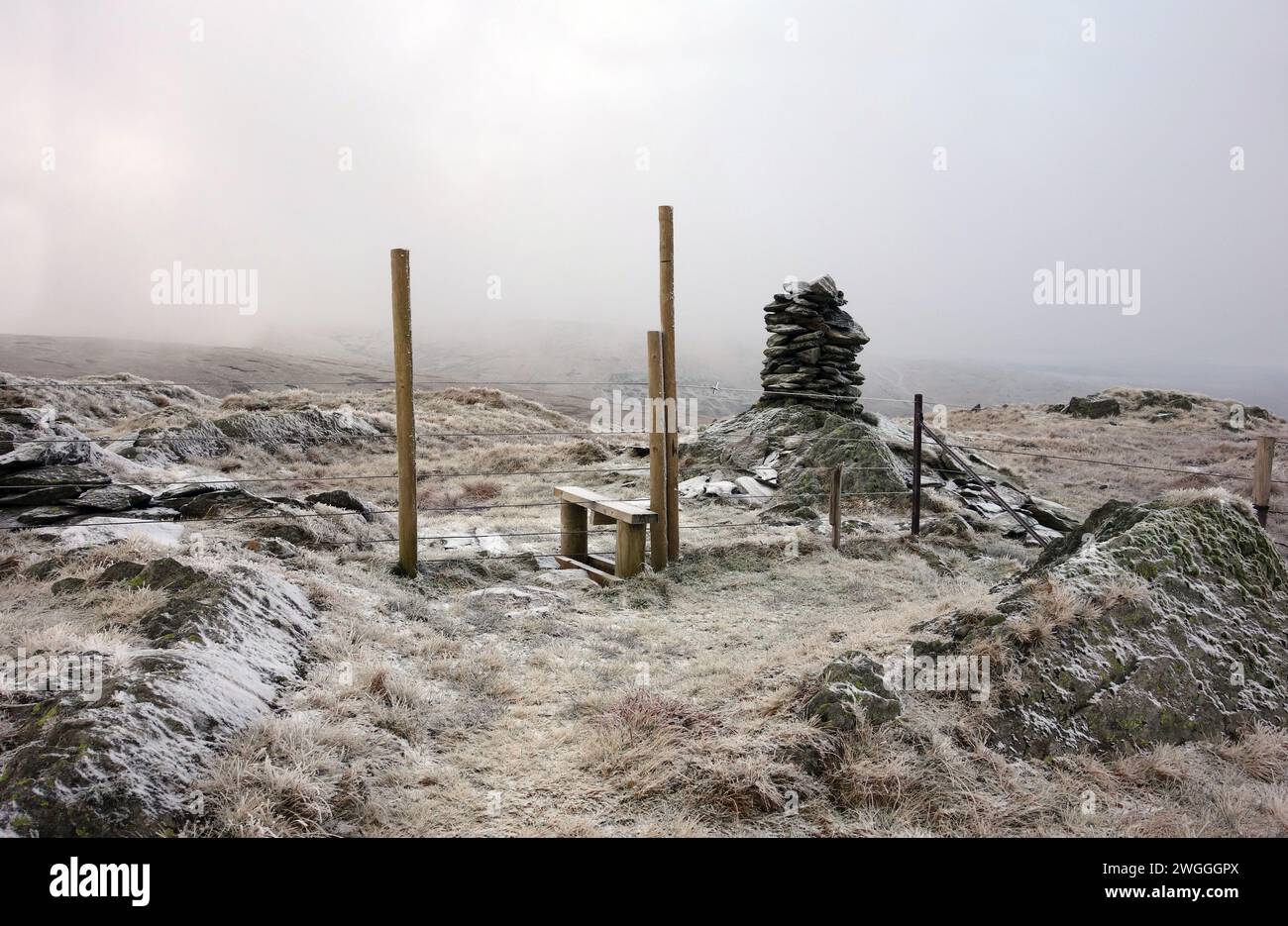 Wooden Stile in Wire Fence & a Stone Cairn on the Summit of the Birkett 'Harrop Pike' Longsleddale, Lake District National Park, Cumbria, England, UK. Stock Photo
