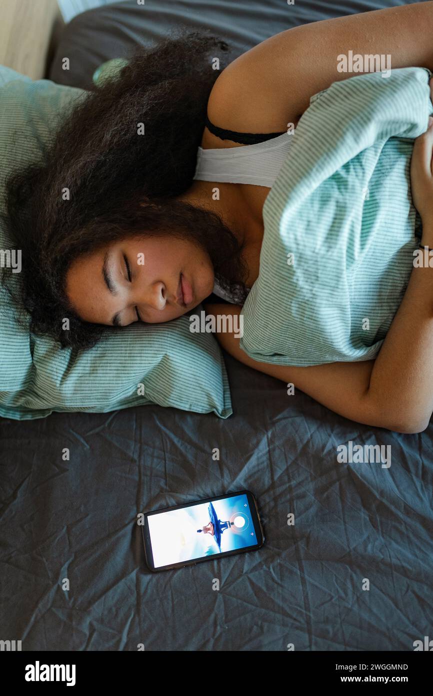 Woman using mobile meditation app to help sleep better. Concept of sleep routine. Insomnia a sleep problems among adults. Stock Photo