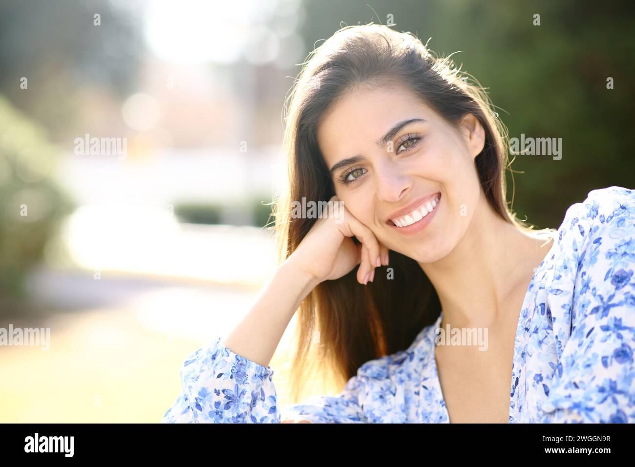 Beauty woman with white smile looks at you in a park Stock Photo