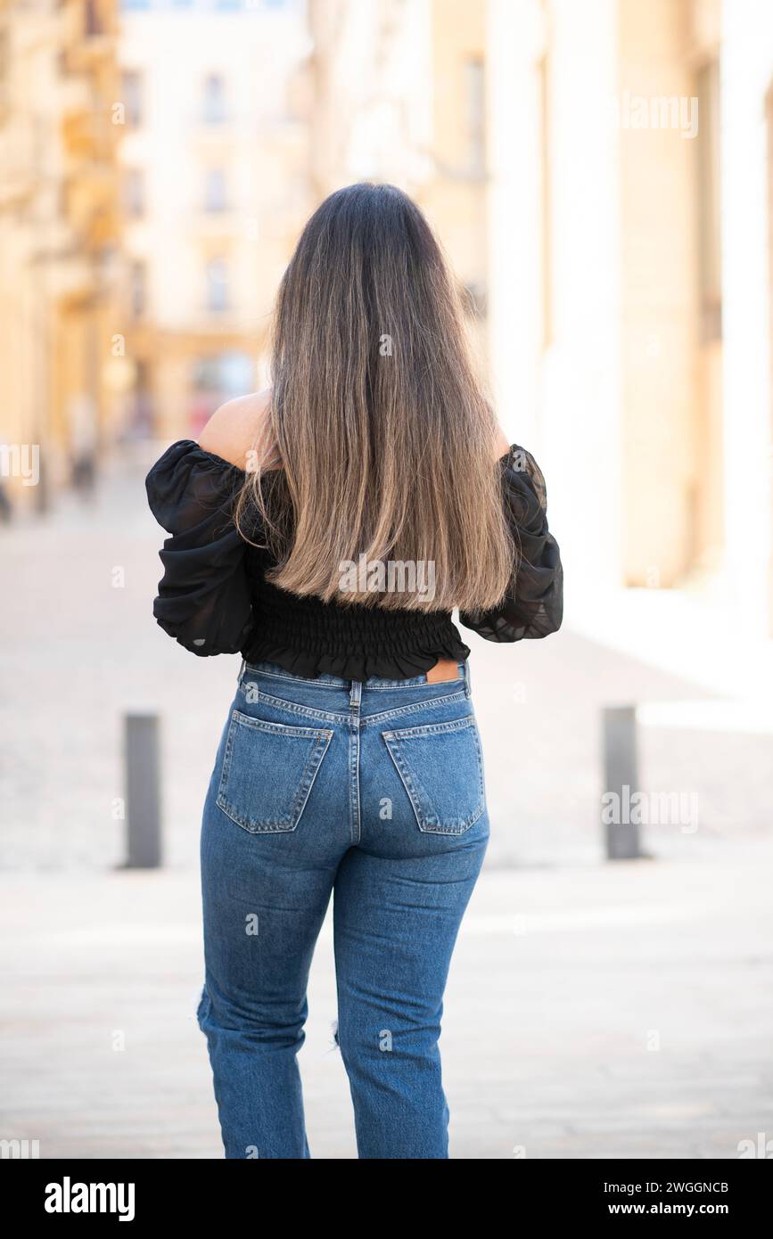 Rear view of woman walking in the street Stock Photo