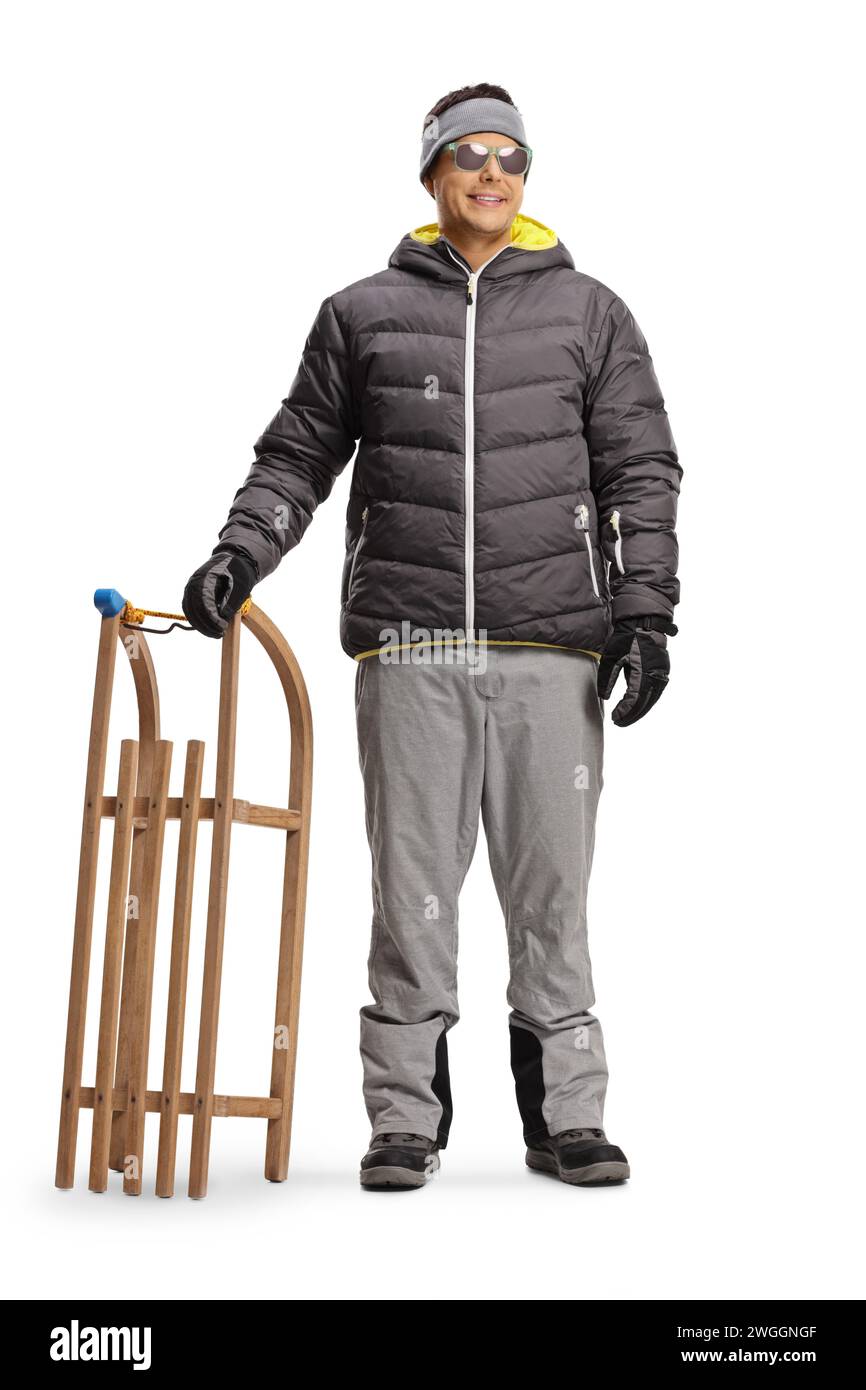 Man in winter clothes standing with a wooden sleigh isolated on white background Stock Photo
