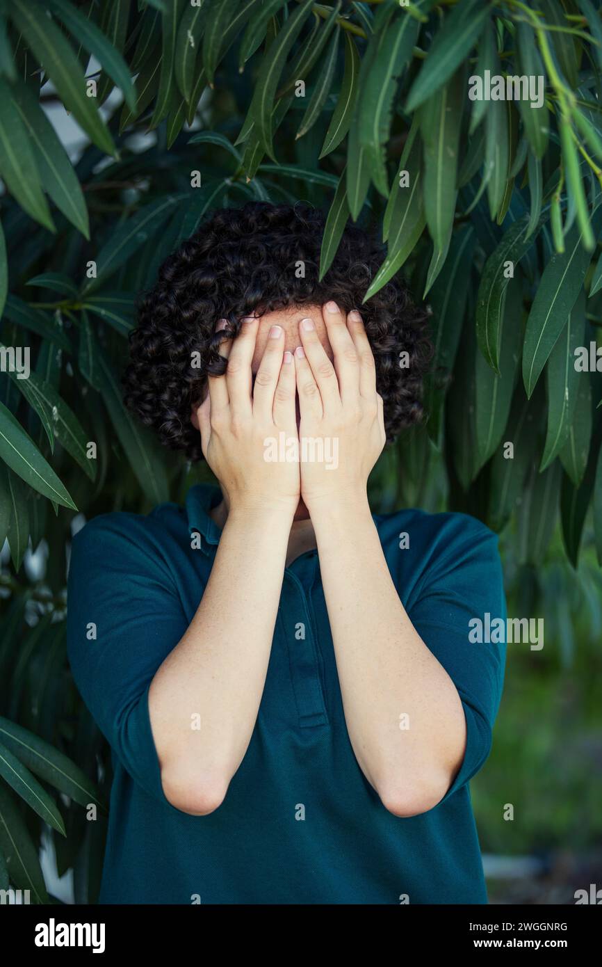 Young woman hiding face wtih eyes crying Stock Photo