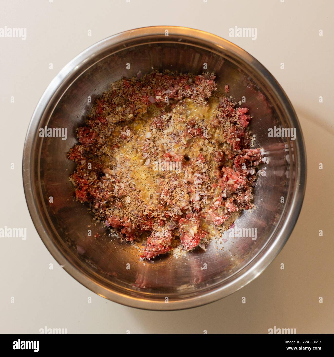 Metal bowl of ground meat with seasonings Stock Photo