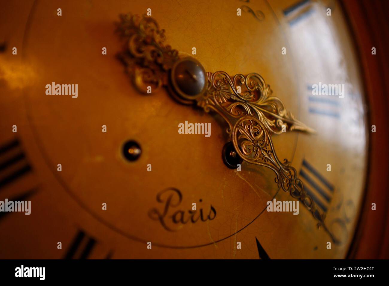 The intricate hands of a well-crafted vintage clock hint at the timeless elegance of a bygone era in Paris. Stock Photo