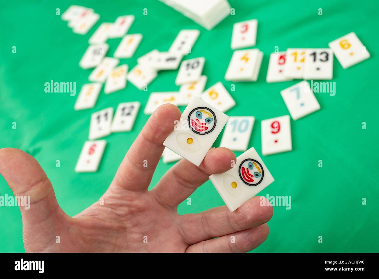 Male hand holding two joker plastic tiles from the game rummikub