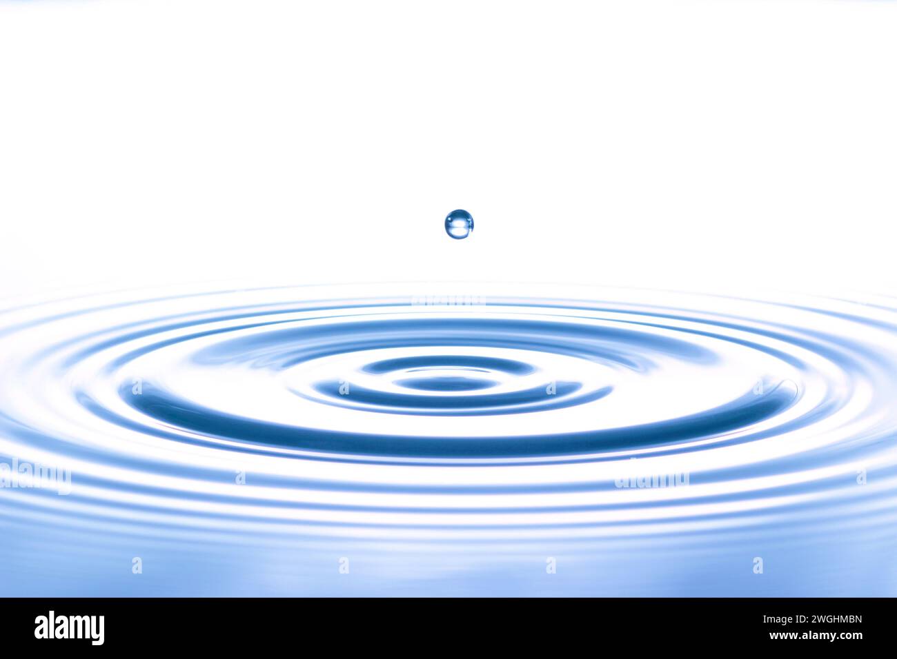 a drop causes circular waves on the water surface Stock Photo