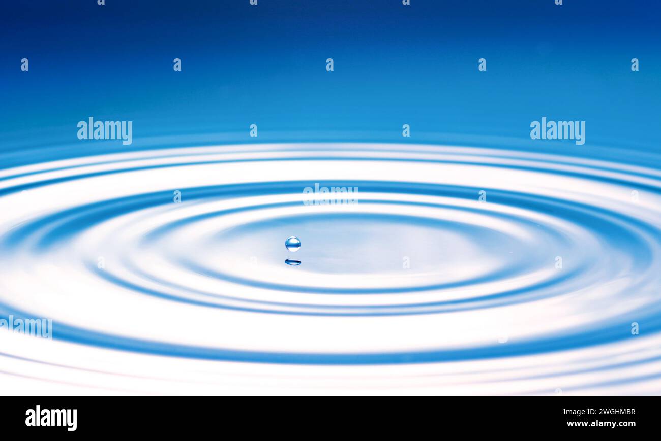 a drop causes circular waves on the water surface Stock Photo
