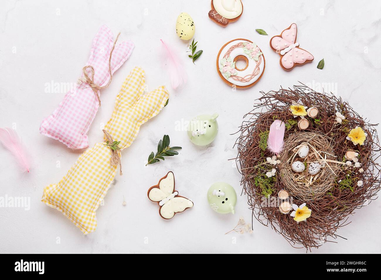 Stylish background with colorful easter cookies with nest on white pastel background. Stock Photo