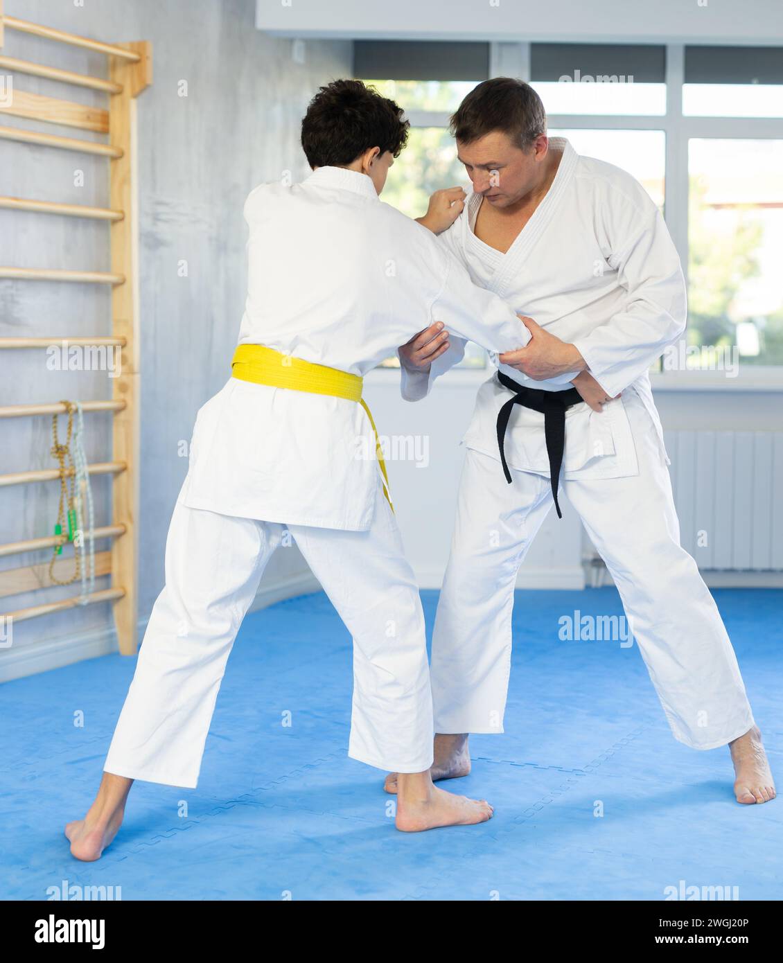 Individual judo lesson for teenager - guy and trainer are sparring in ...