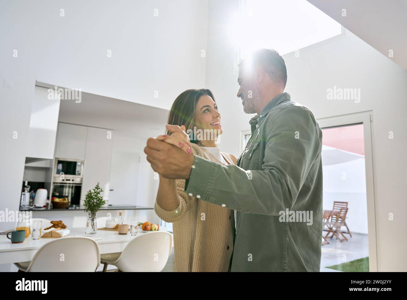 Happy affectionate romantic middle aged mature couple dancing at home Stock Photo