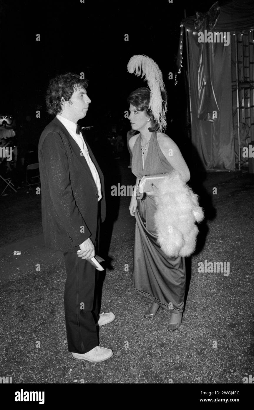 1980s fashion, plumed feather headdress and carrying fur stole, the couple have arrive late not sure where they are supposed to be seated. 1980s London. The annual end of the summer Berkeley Square Ball in London. Westminster, London, England September 1981 HOMER SYKES Stock Photo