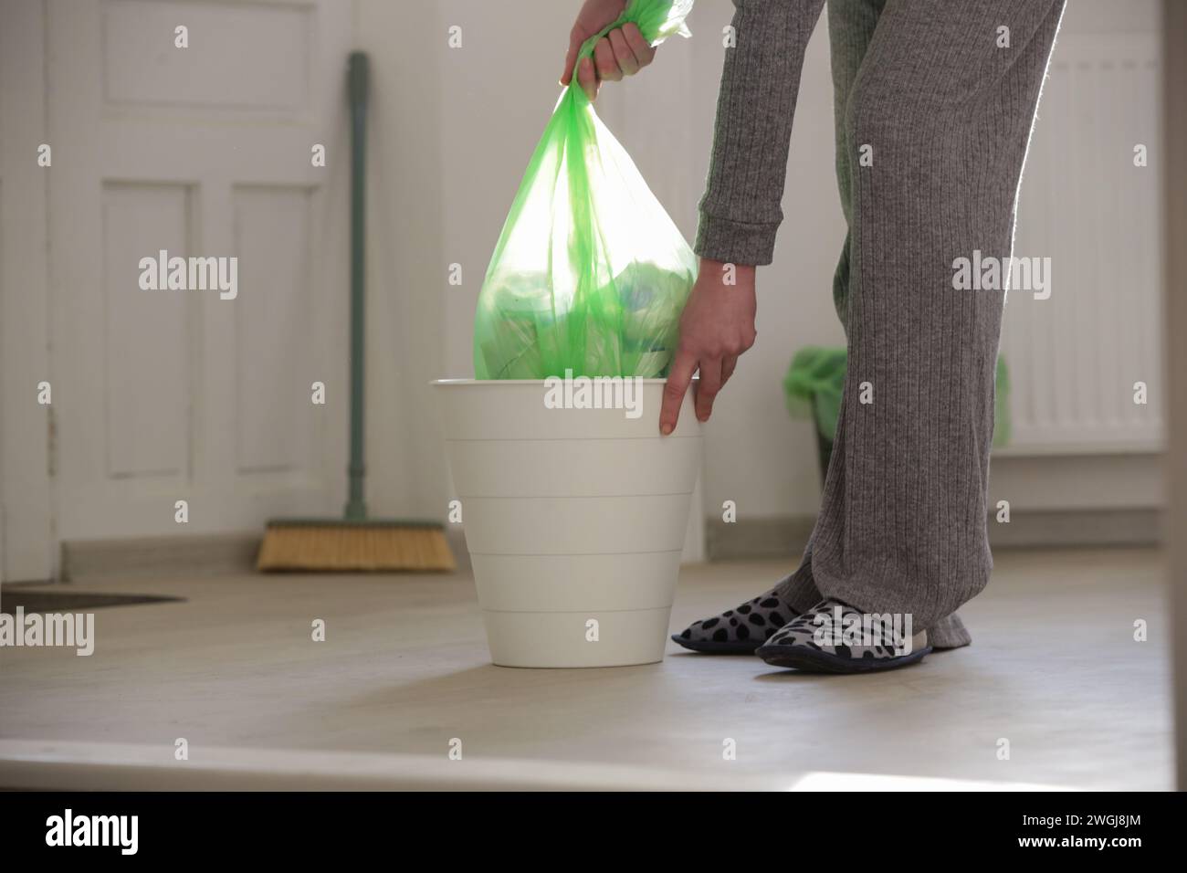 Housewife throwing away garbage, taking of plastic garbage bag from the