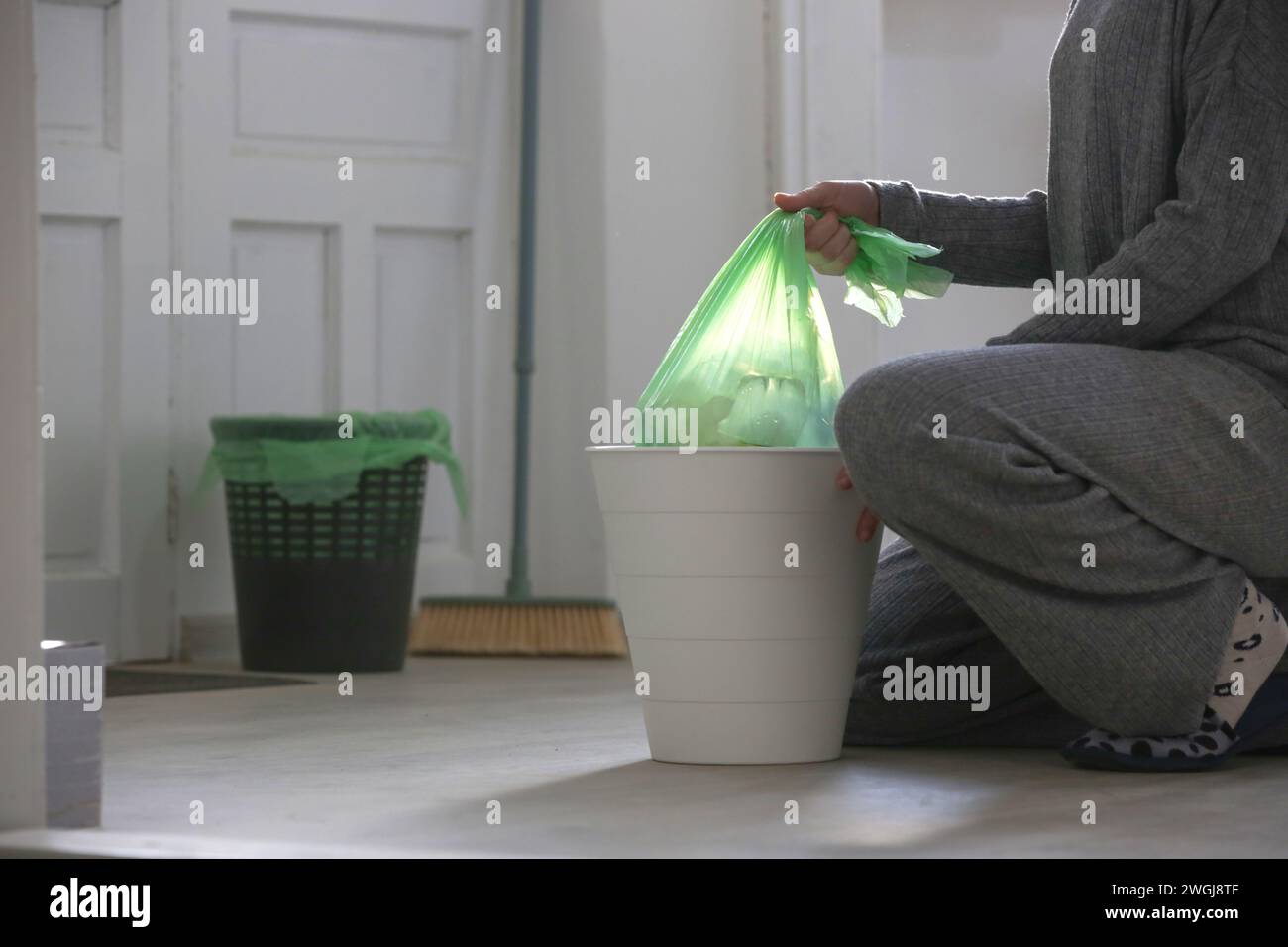 Housewife throwing away garbage, taking of plastic garbage bag from the