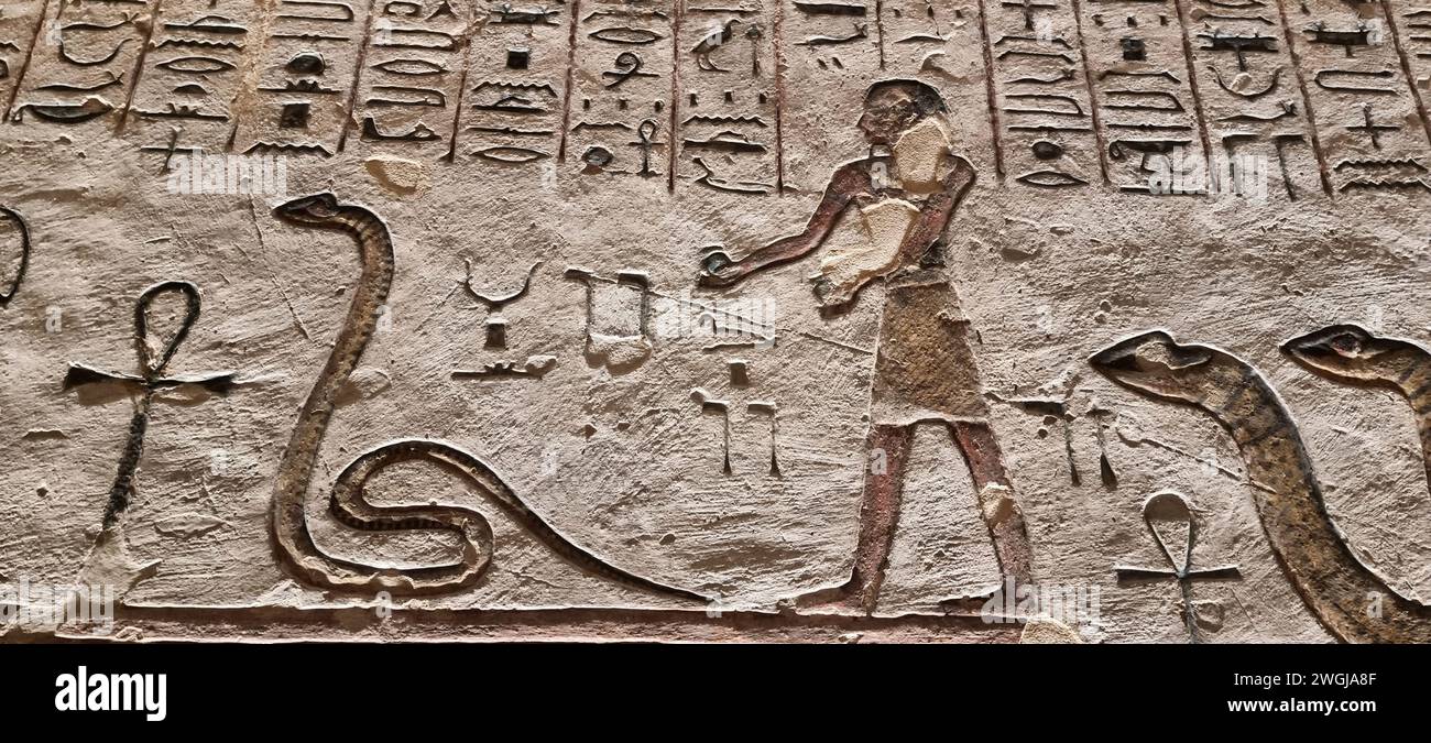 A wall drawing of an Egyptian man with snakes and animals Stock Photo