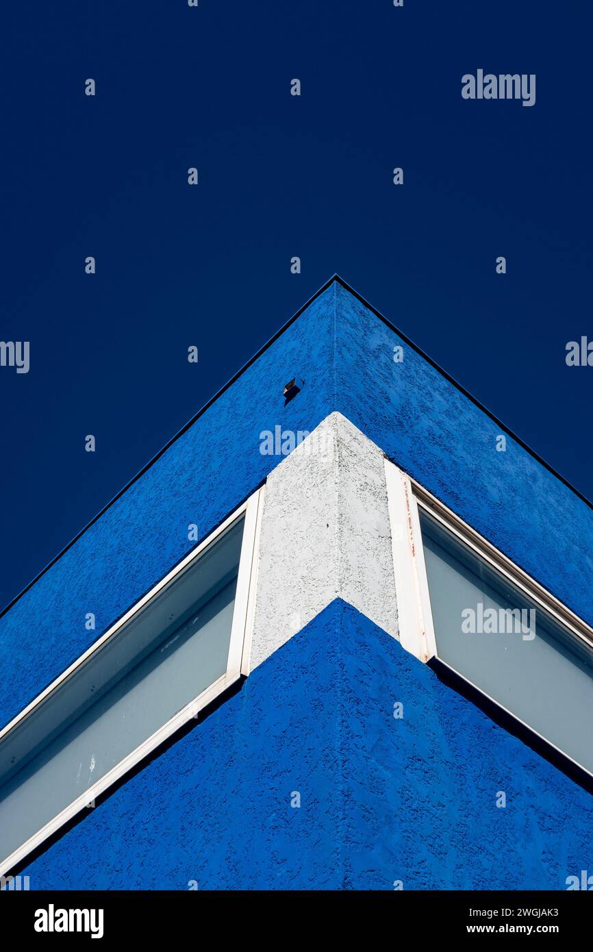 Blue building with white stripe against blue sky Stock Photo