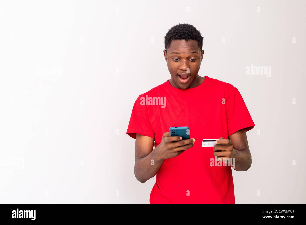 young black man using his phone and credit card Stock Photo