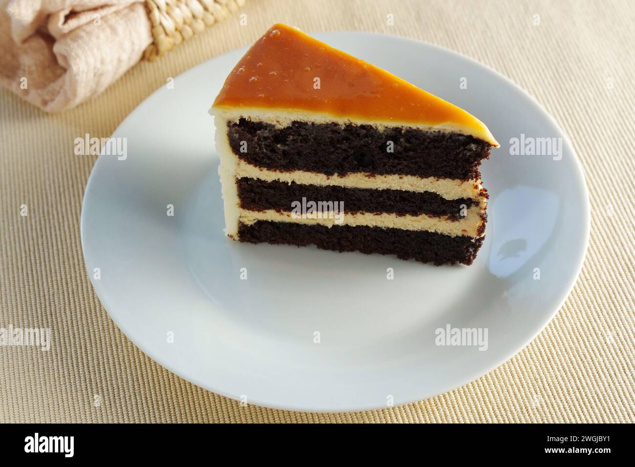 Piece of cake sits elegantly on a pristine white plate, offering a mouthwatering treat. Stock Photo