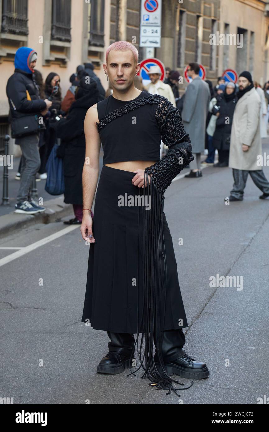 MILAN, ITALY - JANUARY 15, 2024: Man with black singlet and skirt before Giorgio Armani fashion show, Milan Fashion Week street style Stock Photo