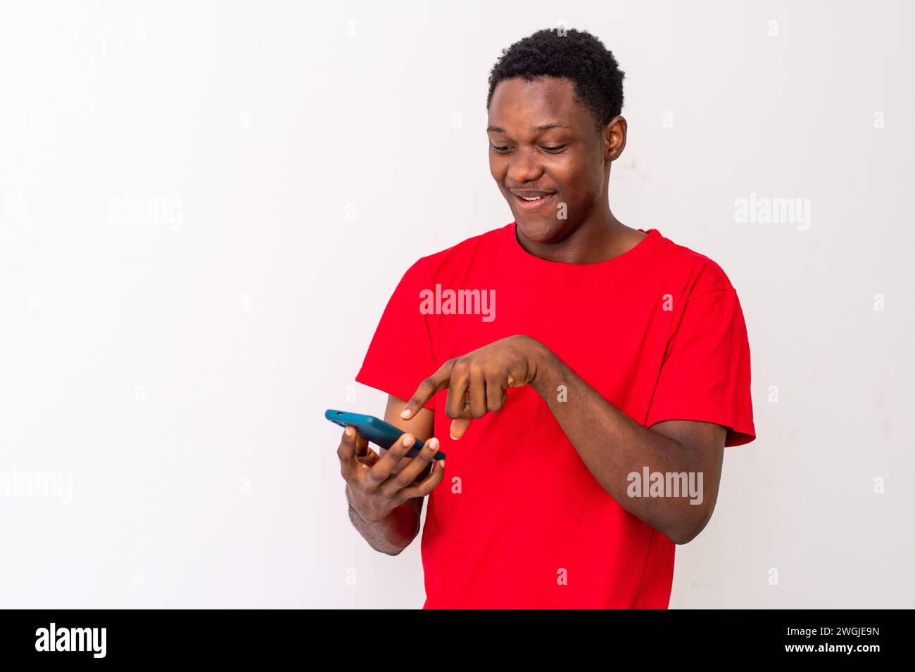 smiling young black man checking his smartphone Stock Photo