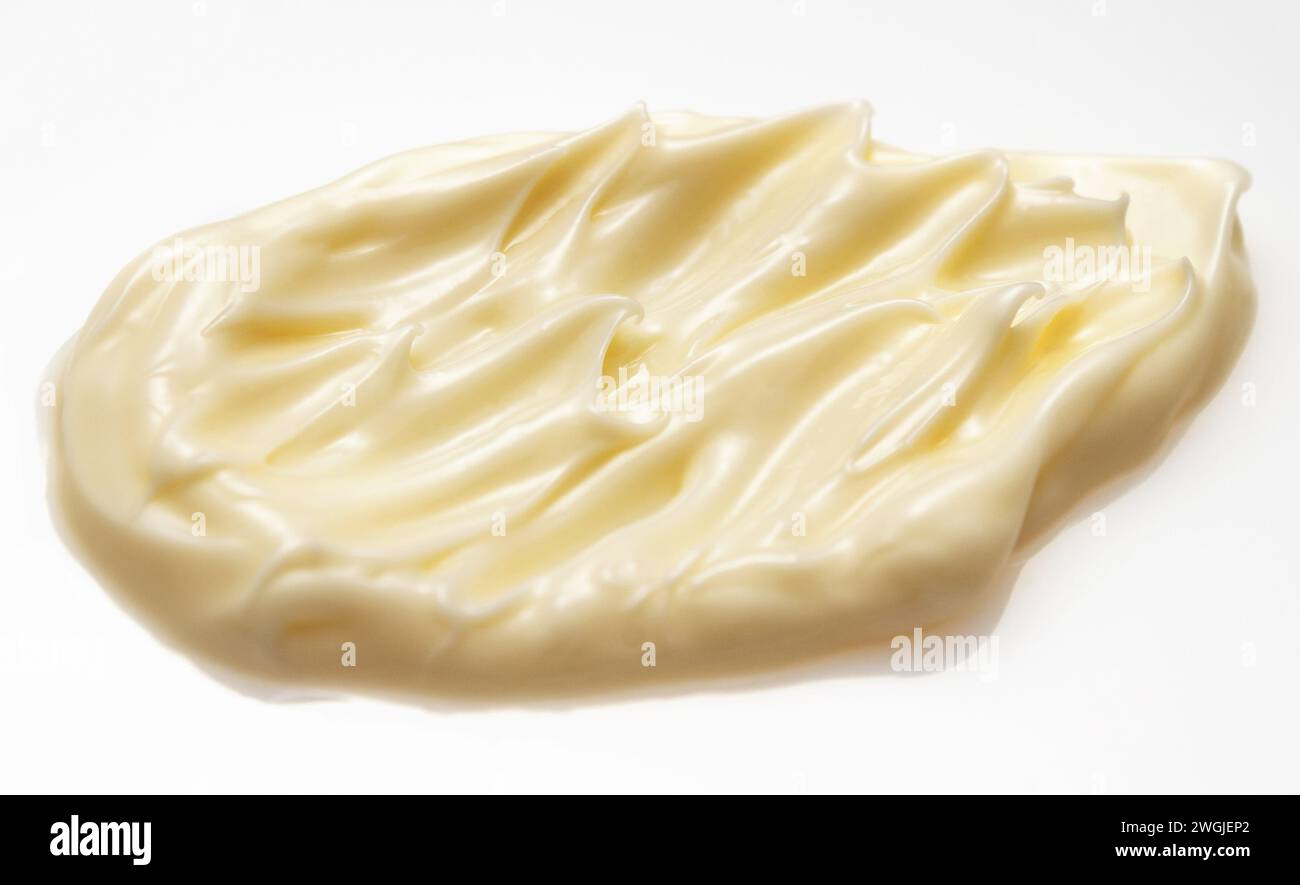 Smears of yellow face or body cosmetic cream on white background. Stock Photo