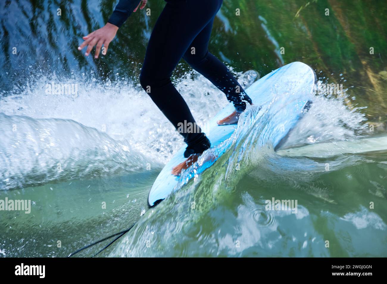 Bodypart of a surfer surfing on the flowings water of a river Stock Photo