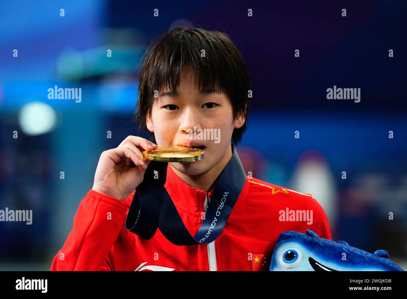 Hongchan Quan of China bites her gold medal after winning the women's