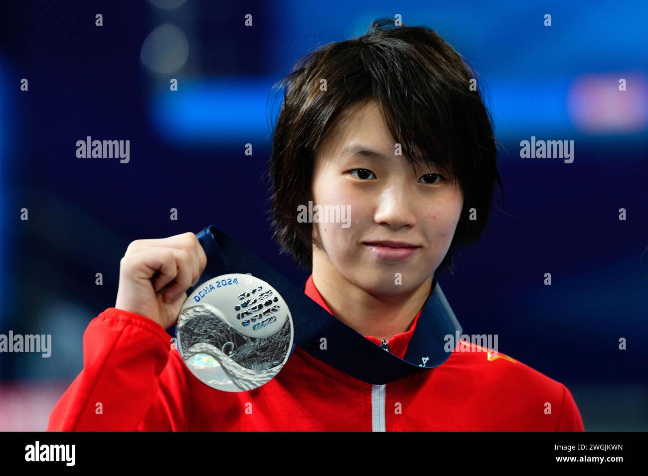Hongchan Quan of China holds up her silver medal during the women's 10m