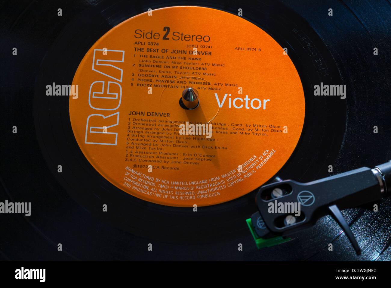 John Denver The Best of John Denver vinyl record album LP with tonearm, cartridge, headshell and stylus on turntable record player - 1972 Stock Photo