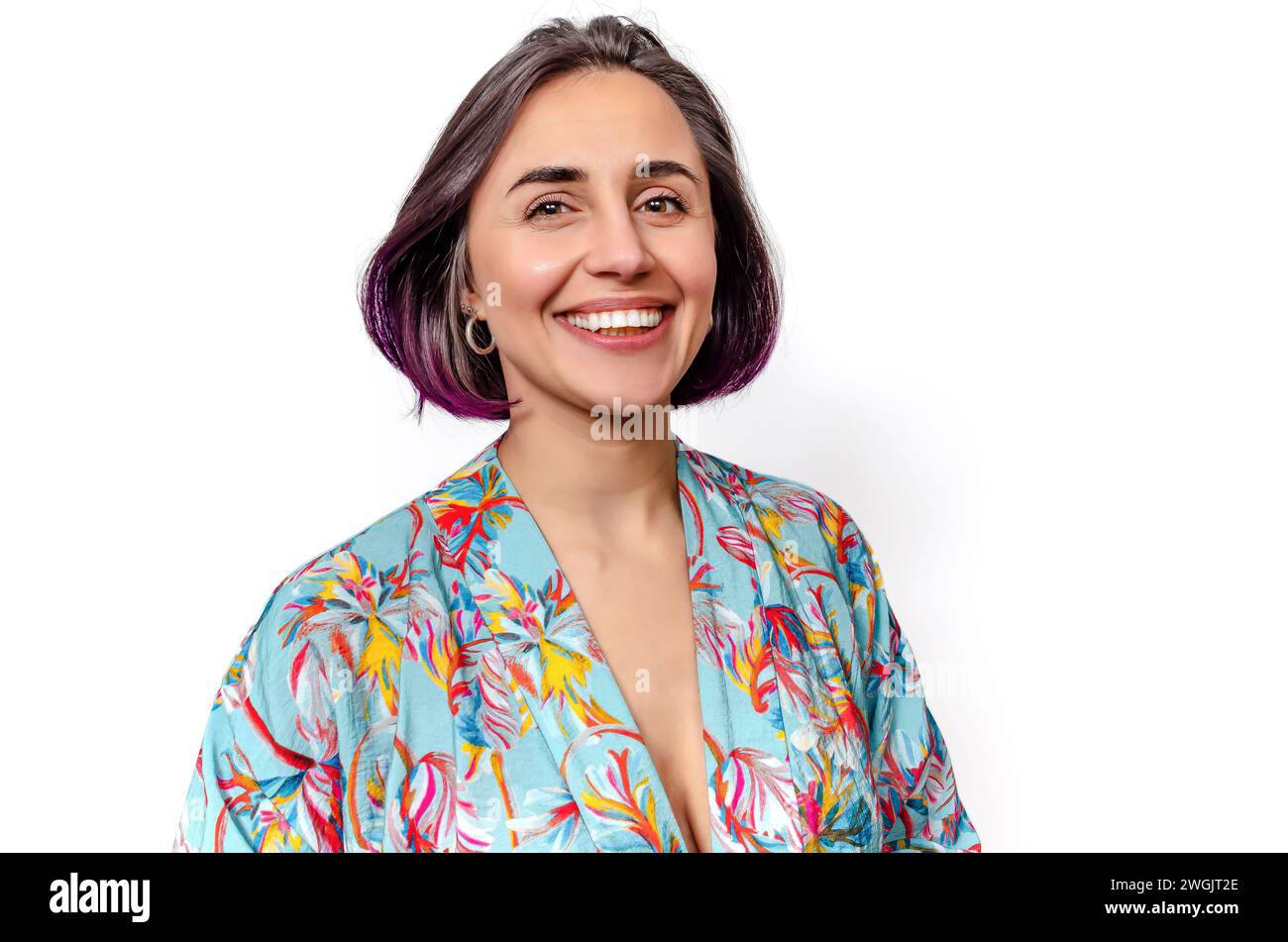 Dark-haired woman smiles a wide smile, showing perfect teeth. Blouse with deep neckline. Stock Photo