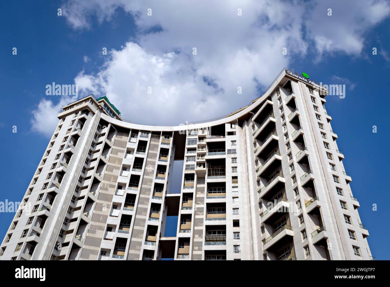 Tall city building with a background of beautiful fluffy blue clouds sky in the background. Stock Photo