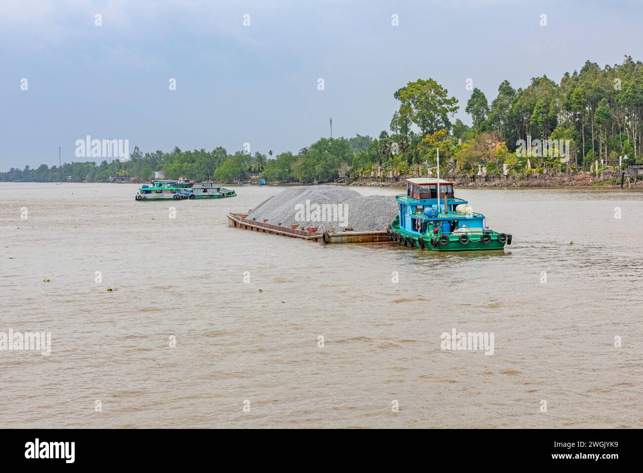 A heavily laden cargo boat and barge on the Mekong river delta, Vietnam. Stock Photo