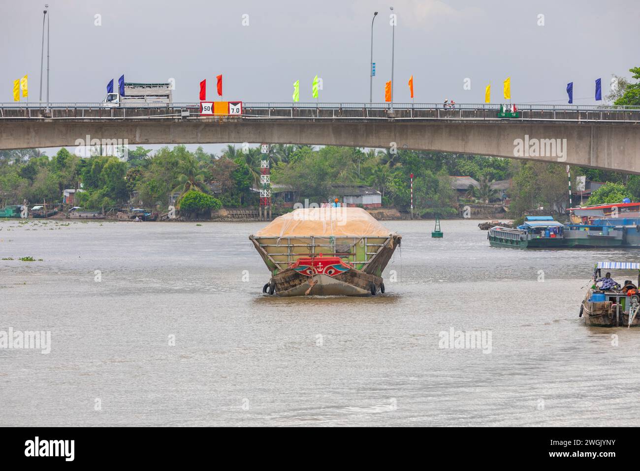 A heavily laden cargo boat on the Mekong river delta, in Vinh Long, Vietnam. Stock Photo