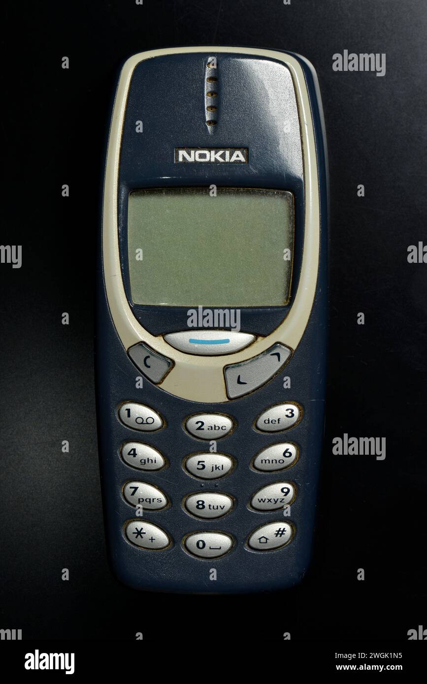 Used classic Nokia 3310 mobile cell phone on black Stock Photo