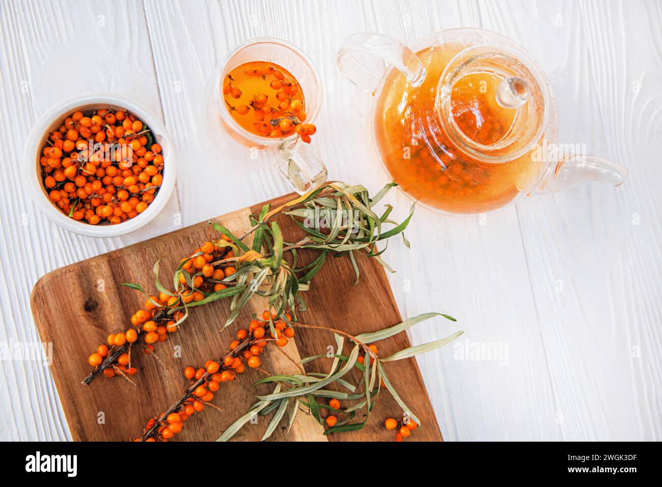 sea buckthorn tea steeping in a clear teapot, a delicious blend. tea time with fresh sea buckthorn leaves and berries Stock Photo
