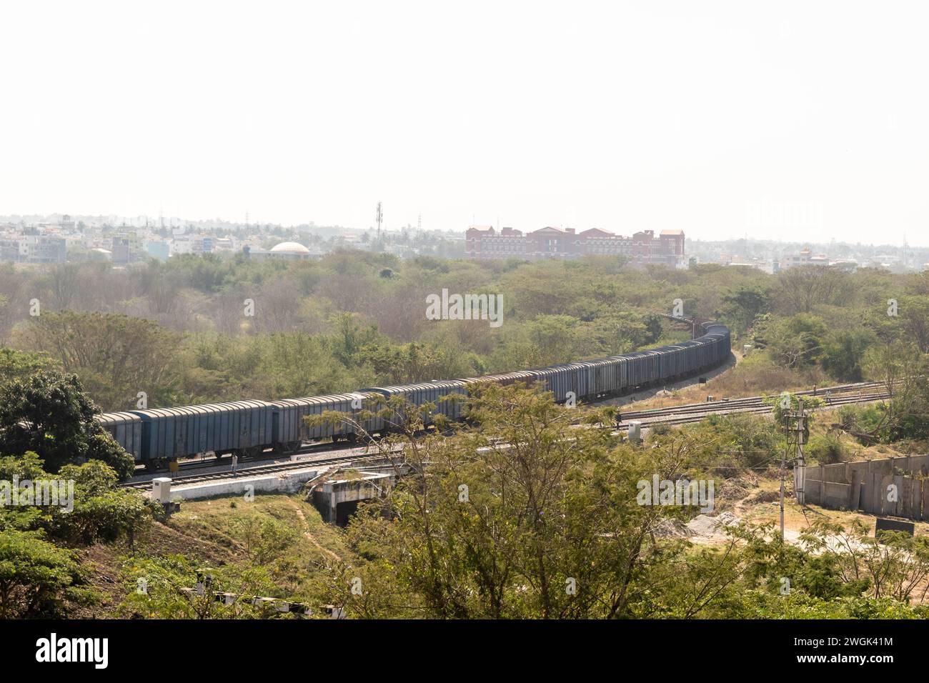 A lengthy freight train snakes its way around a gentle curve amid the ...