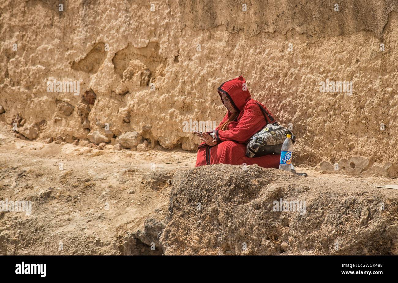 A woman seated in the outskirts of Tangier, a Moroccan port on the Strait of Gibraltar, has been a strategic gateway between Africa and Europe since Phoenician times. Its whitewashed hillside medina is home to the Dar el Makhzen, a palace of the sultans that's now a museum of Moroccan artifacts. The American Legation Museum, also in the medina, documents early diplomatic relations between the U.S. and Morocco in an 1821 Moorish-style former consulate. Morocco. Stock Photo