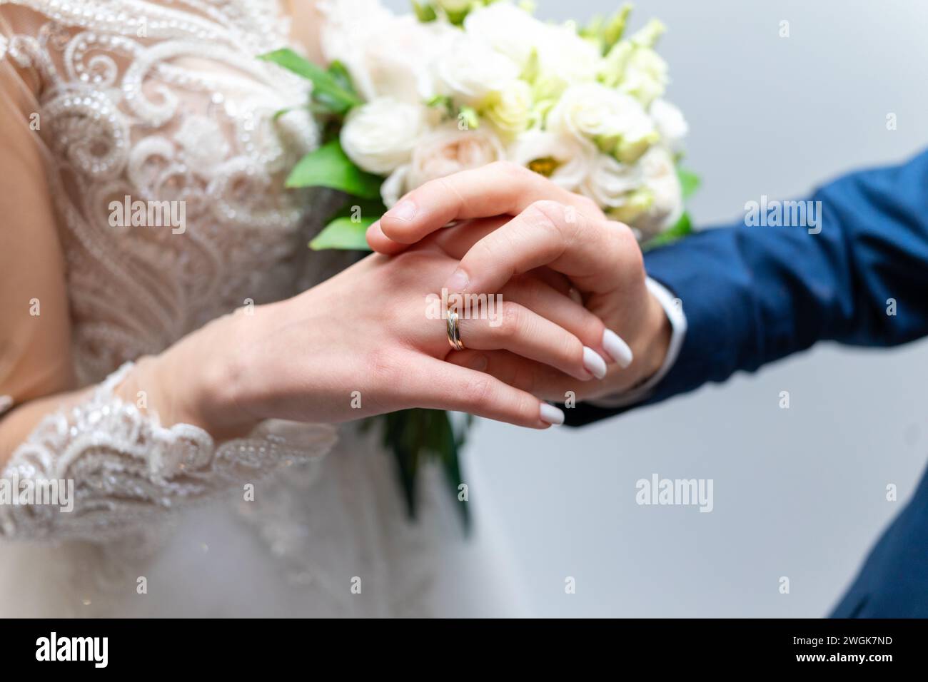 The groom puts a wedding ring on the bride's finger. Stock Photo