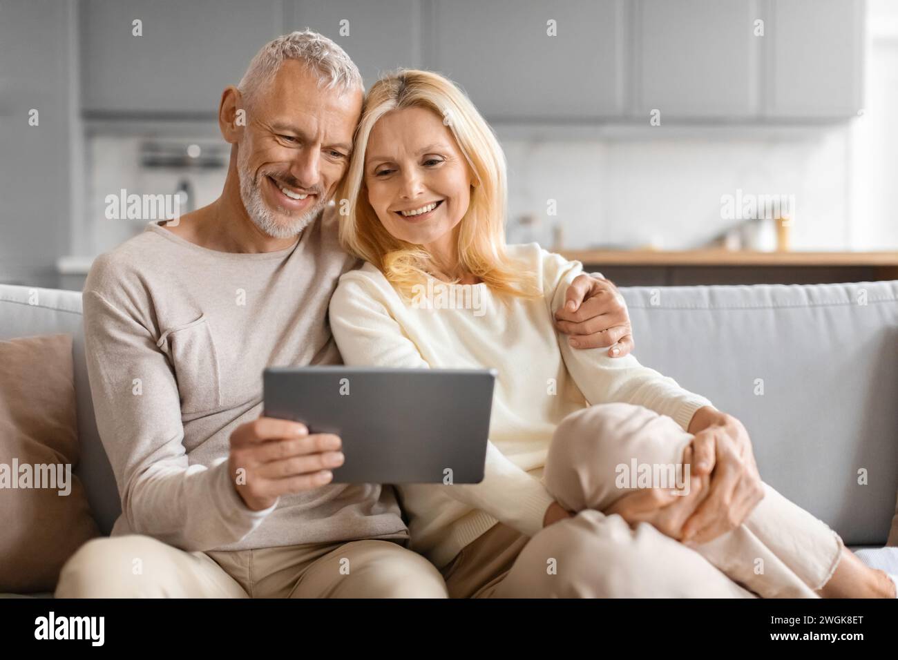 Happy Senior Couple Using Digital Tablet Together Browsing Internet Stock Photo
