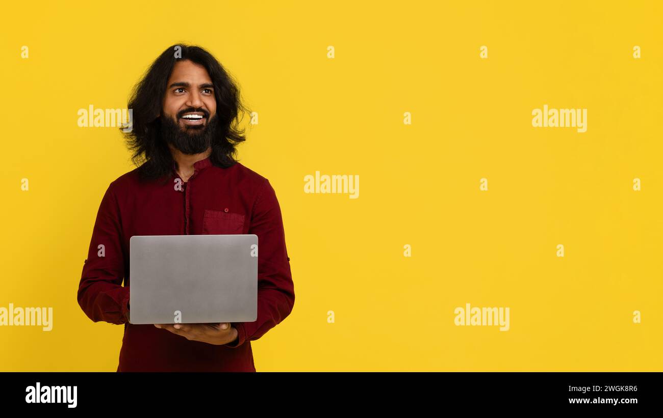 Happy attractive stylish young indian guy using modern notebook Stock Photo