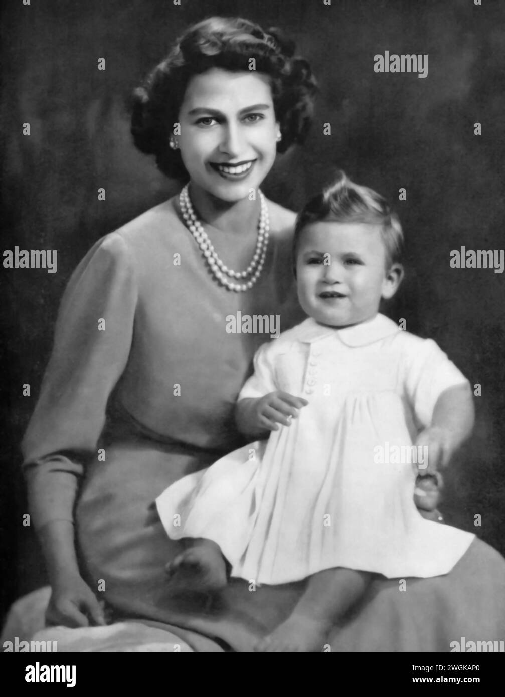 Portrait of Elizabeth II holding her son, Charles III, in the early 1950s. Before her ascension to the throne in 1952, Elizabeth is seen here with Charles, born November 14, 1948. This photo captures a tender moment between the future queen and the young prince, who would become King Charles III in 2022, highlighting their early bond in the royal family. Stock Photo