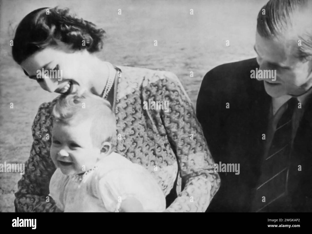 Photograph of a young Charles III seated on the lap of his mother, Elizabeth II, with his father, Prince Philip, seated beside them. This family portrait, likely taken in the early 1950s, shows the future King Charles III in his early childhood, alongside his parents before Elizabeth's ascension to the throne in 1952. The image captures a personal moment in the life of the royal family, before Elizabeth and Philip's roles as queen and consort were fully realized. Stock Photo