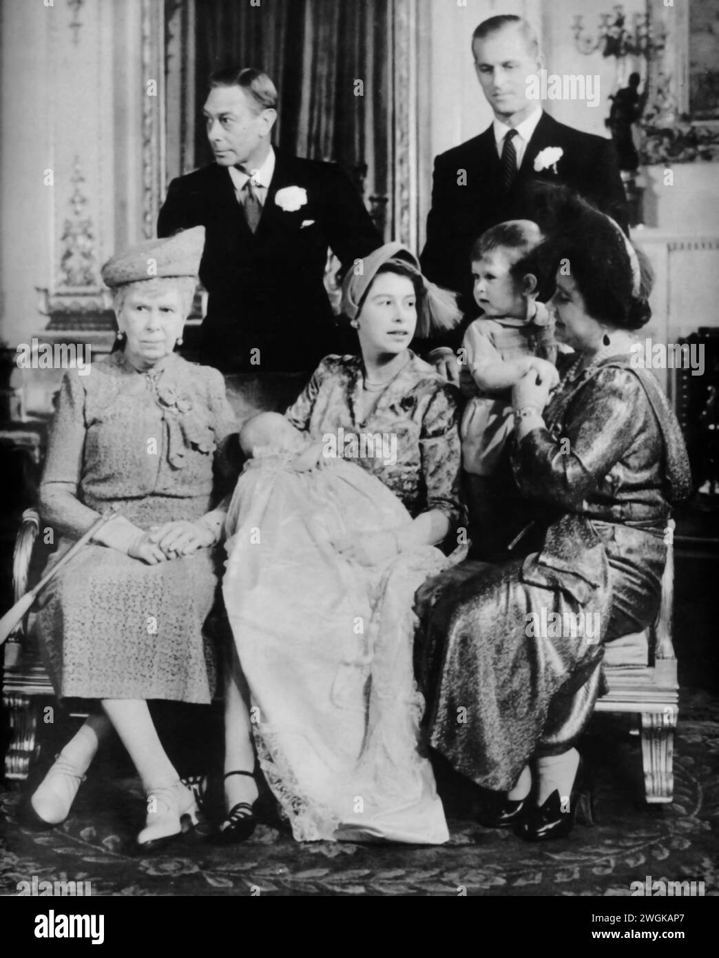 A portrait featuring Elizabeth II, Prince Philip, King George VI, Elizabeth I (the Queen Mother), Queen Mary, and newborn, Princess Anne. Taken during the time of Princess Anne's christening in 1950, brings together multiple generations of British royalty. The photograph captures a historic moment, of the royal lineage with Queen Mary, the reigning King George VI, and the future monarchs Elizabeth II and Princess Anne. Stock Photo